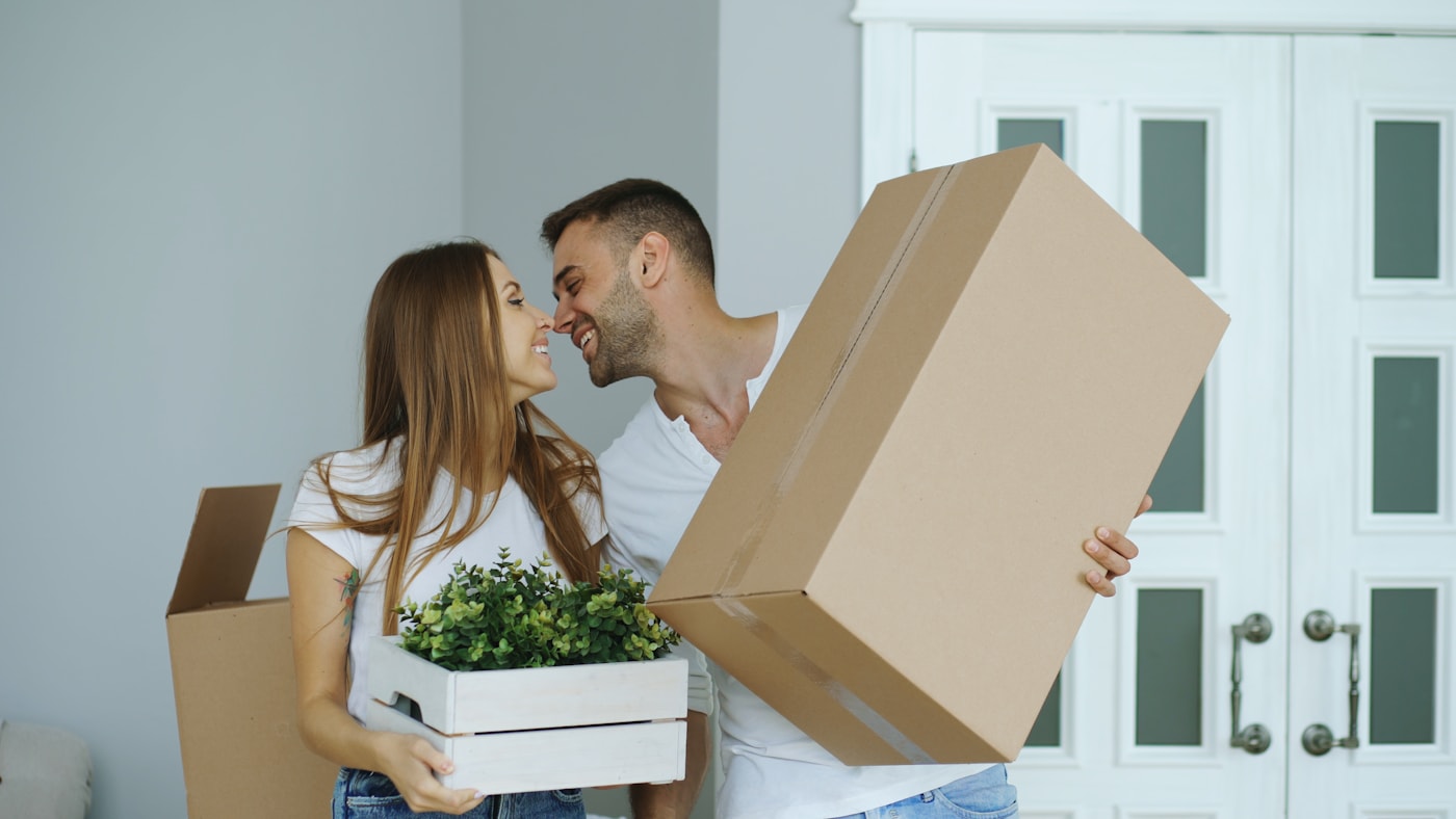 A happy couple carrying moving boxes into their new San Francisco home