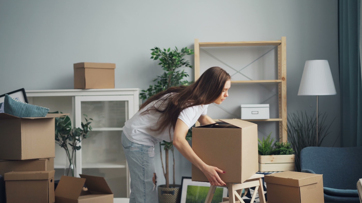 Packing moving boxes carefully in a bright San Francisco living room